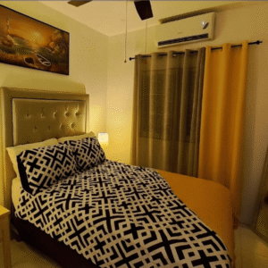 Bedroom at Serenity Dream featuring gold curtains, geometric-patterned bedding, wall art, and air conditioning