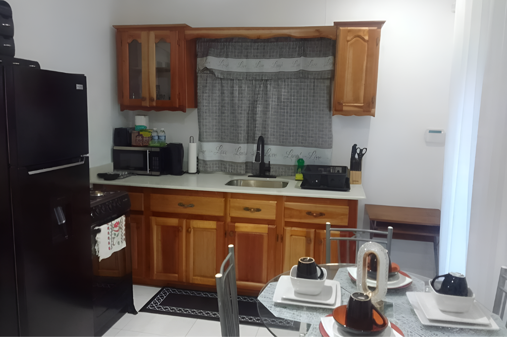 Wooden cabinet kitchen with microwave, sink, stove, and countertop setup