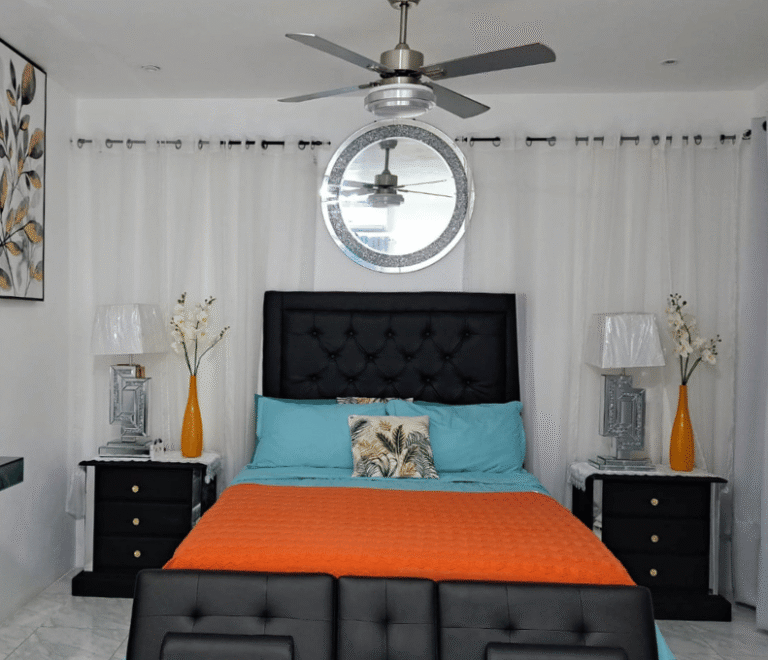Spacious master bedroom in Serenity Haven Suite featuring turquoise accents and a tufted headboard
