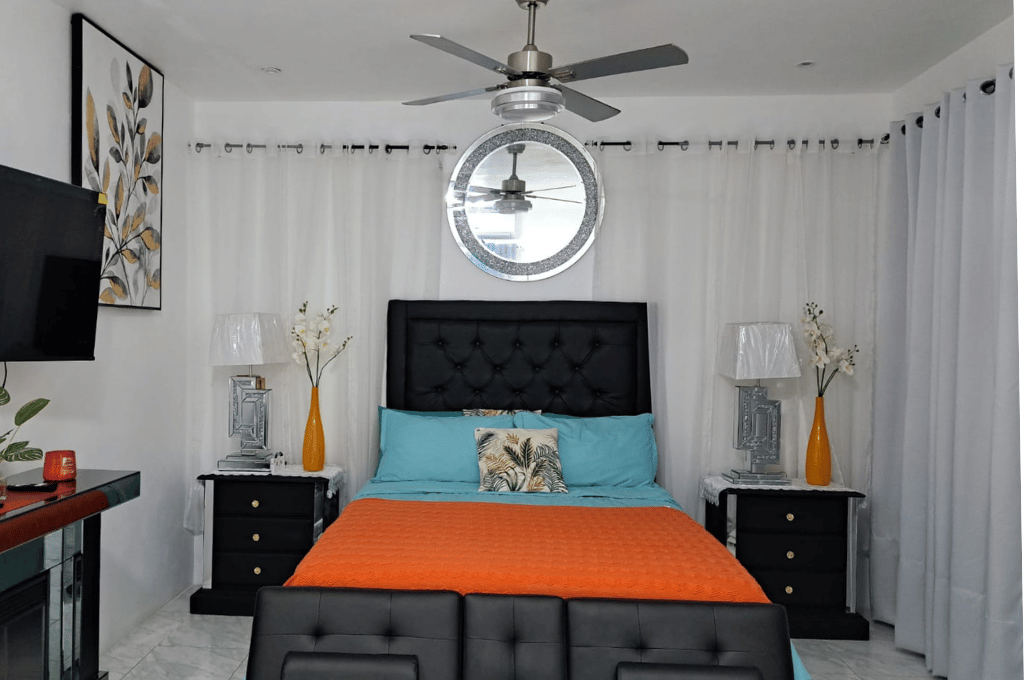 Spacious master bedroom in Serenity Haven Suite featuring turquoise accents and a tufted headboard