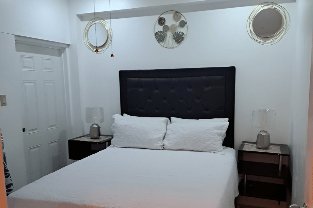 Modern bedroom at Serenity Whisper Retreat with white décor and queen bed