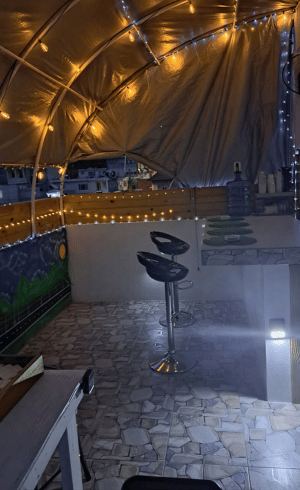 Outdoor nighttime lounge area with string lights and bar stools at Mountain Echo Suites